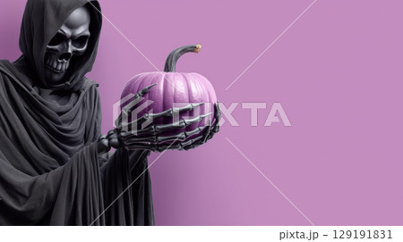 Grim reaper with skeletal hands holds purple pumpkin against solid purple background, creating spooky Halloween vibe 129191831