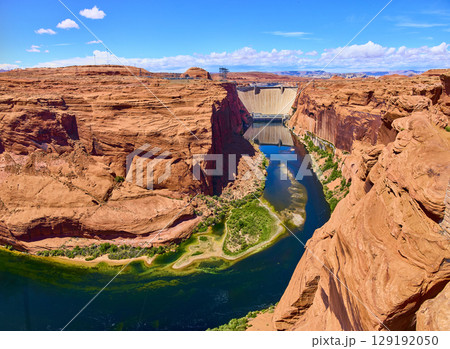Aerial Fly Over Glen Canyon Dam Colorado River and Red Sandstone Cliffs 129192050