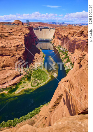Aerial Fly Over Glen Canyon Dam Colorado River and Red Sandstone Cliffs 129192114