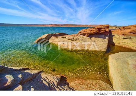 Red Sandstone Shoreline and Clear Lake Water with Desert Sky Eye Level 129192143
