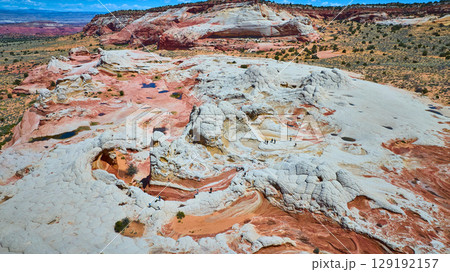 Aerial Swirling Sandstone Formations with Pools and Hikers White Pocket Fly Over 129192157