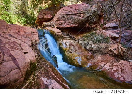 Waterfall Motion Over Red Sandstone Rocks in Canyon Eye Level View 129192309