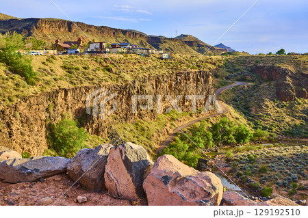Desert Canyon Cliffs with Suburban Homes and Winding Road Eye Level Overlook 129192510