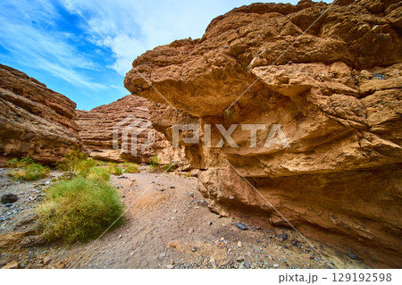 Rugged Red Rock Formations in Desert Sunlit Pathway Perspective Rugged Red Rock Formations in Desert Sunlit Pathway Perspective 129192598