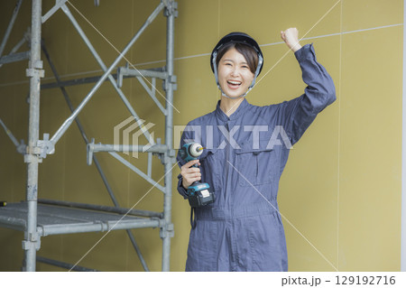 建築現場で働く若い女性作業員 建築現場で働く若い女性作業員 129192716
