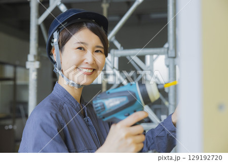 建築現場で働く若い女性作業員 建築現場で働く若い女性作業員 129192720