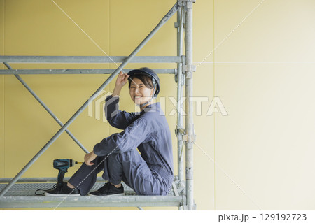 建築現場で働く若い女性作業員 建築現場で働く若い女性作業員 129192723