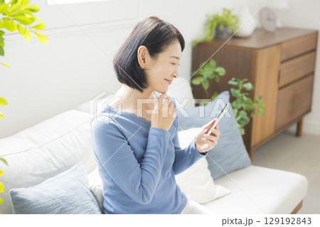 スマホを使うミドル女性 129192843