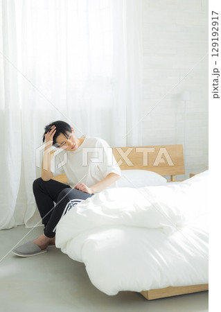 ベッドに座る若い男性 ベッドに座る若い男性 129192917