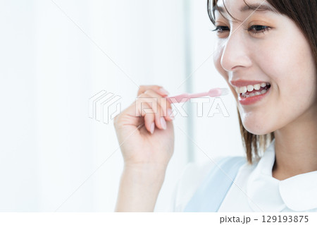 歯磨き指導をする歯科スタッフの女性 129193875