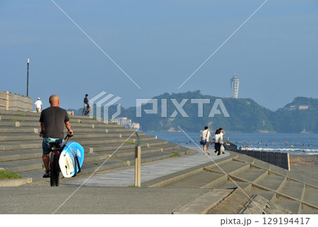 鵠沼海岸遊歩道を自転車で移動するサーファー 129194417