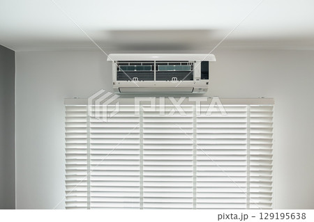 Air conditioner above blind and window. Air conditioner above blind and window. 129195638