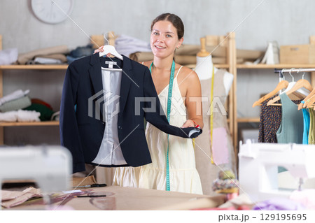 dressmaker presents a finished black jacket 129195695