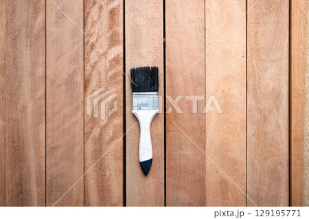 Paint brush and wood material in construction work. 129195771