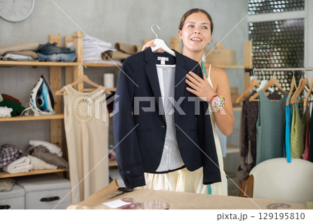 dressmaker presents a finished black jacket 129195810