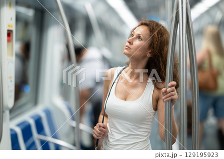 Portrait of woman traveling by modern city subway carriage 129195923