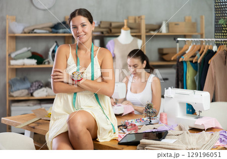 Young woman tailor designer is in sewing office Young woman tailor designer is in sewing office 129196051