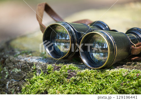 Old binoculars offer a unique perspective on nature's serene beauty. Old binoculars offer a unique perspective on nature's serene beauty. 129196441
