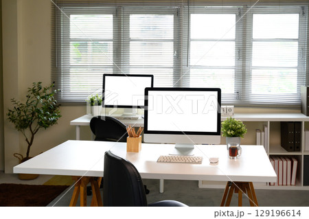 Modern workspace with blank desktop computers for advertising or branding mockups Modern workspace with blank desktop computers for advertising or branding mockups 129196614