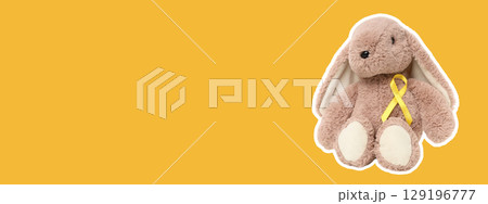 Cute stuffed bunny toy with a cheerful yellow ribbon on display 129196777