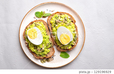 Avocado toast with boiled egg, sunflower seeds, pumpkin seeds and sesame seeds, Healthy eating Avocado toast with boiled egg, sunflower seeds, pumpkin seeds and sesame seeds, Healthy eating 129196929