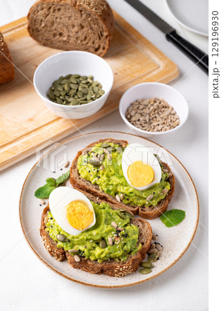 Avocado toast with boiled egg, sunflower seeds, pumpkin seeds and sesame seeds, Healthy eating Avocado toast with boiled egg, sunflower seeds, pumpkin seeds and sesame seeds, Healthy eating 129196930