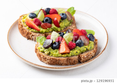 Avocado toast with strawberry, blueberry, raspberry and grape. Healthy eating 129196931