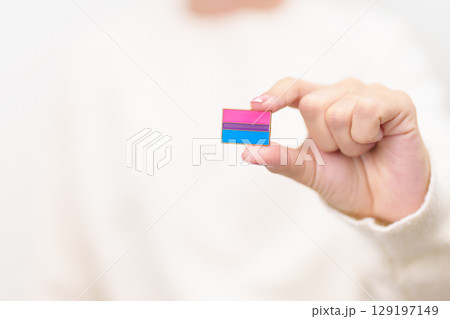 Bisexuality Celebrate Day and LGBT pride month, LGBTQ or LGBTQIA concept. Hand holding purple, pink and blue flag shape for Lesbian, Gay, Bisexual, Transgender, Queer, Pansexual, Marriage Equality Law 129197149
