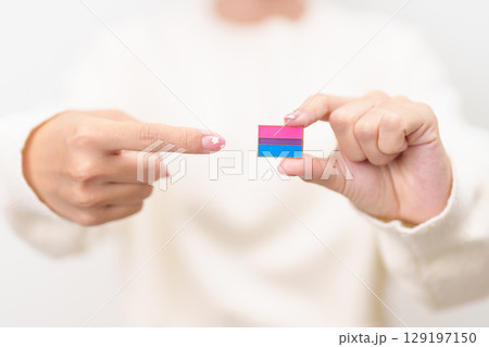 Bisexuality Celebrate Day and LGBT pride month, LGBTQ or LGBTQIA concept. Hand holding purple, pink and blue flag shape for Lesbian, Gay, Bisexual, Transgender, Queer, Pansexual, Marriage Equality Law Bisexuality Celebrate Day and LGBT pride month, LGBTQ or LGBTQIA concept. Hand holding purple, pink and blue flag shape for Lesbian, Gay, Bisexual, Transgender, Queer, Pansexual, Marriage Equality Law 129197150