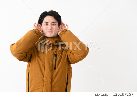 ダウンコートを着ている若い男性 129197257