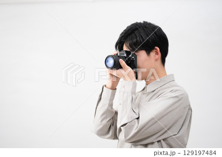 フィルムカメラを持っている若い男性 129197484