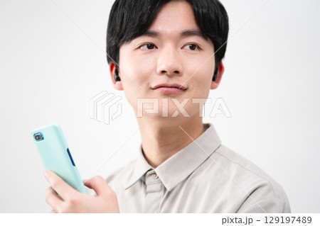 有線イヤホンで音楽を聴く若い男性 有線イヤホンで音楽を聴く若い男性 129197489