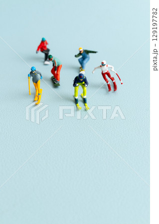Miniature figurines of skiers and snowboarders posed in a dynamic winter sports lineup Miniature figurines of skiers and snowboarders posed in a dynamic winter sports lineup 129197782