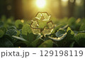 Golden glitter recycling symbol above green leaves in sunlight 129198119