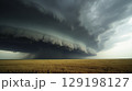 A massive supercell thunderstorm forms over a golden wheat field 129198127