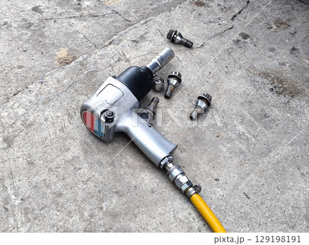 Pneumatic Air Impact Wrench with Lug Nuts. Car Tire Repair 129198191