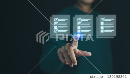Hand person pointing at a virtual checklist with complete task, symbolizing task management, customer service, quality control, productivity and efficient work processes in a digital environment. 129198261