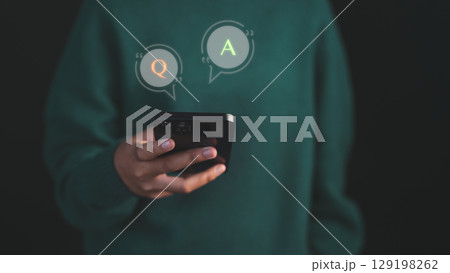 Young woman using a smartphone with virtual Q&A speech bubbles, representing online communication, chatbot AI systems, or customer support interaction. 129198262