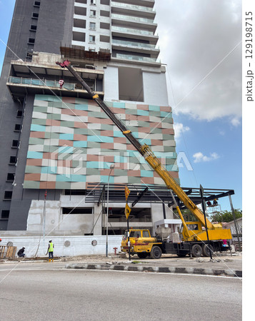 Construction work on modern building with crane in Penang, Malaysia Construction work on modern building with crane in Penang, Malaysia 129198715