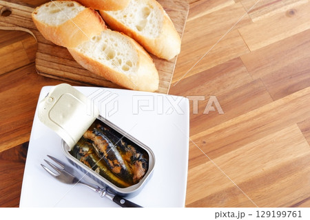 オイルサーディンとバゲット - イワシをオリーブオイルに漬けたオイルサーディンと、焼きたてのバゲット 129199761