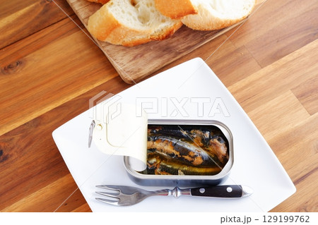 オイルサーディンとバゲット - イワシをオリーブオイルに漬けたオイルサーディンと、焼きたてのバゲット 129199762