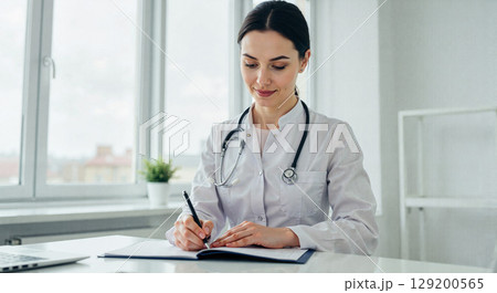 Doctor writing notes in modern clinic 129200565