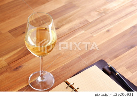 白ワインを飲みながら、リング式のシステム手帳に日記をつけているイメージ写真 白ワインを飲みながら、リング式のシステム手帳に日記をつけているイメージ写真 129200931