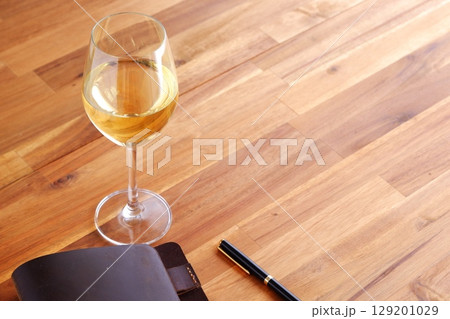 白ワインを飲みながら、茶色の革のシステム手帳に日記をつけているイメージ 白ワインを飲みながら、茶色の革のシステム手帳に日記をつけているイメージ 129201029