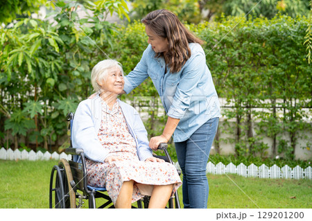 Caregiver help and care Asian senior woman patient sitting on wheelchair at nursing hospital ward, healthy strong medical. Caregiver help and care Asian senior woman patient sitting on wheelchair at nursing hospital ward, healthy strong medical. 129201200