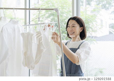 洗濯物を干す50代の女性 129201588