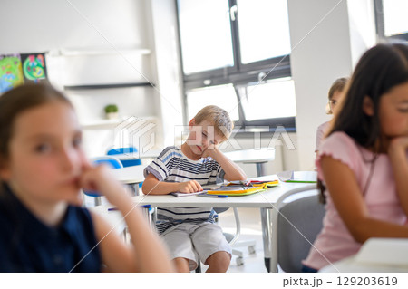 Tired schoolboy struggling to stay awake during class Tired schoolboy struggling to stay awake during class 129203619