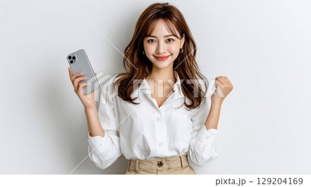 スマホを手に笑顔でガッツポーズする女性 スマホを手に笑顔でガッツポーズする女性 129204169