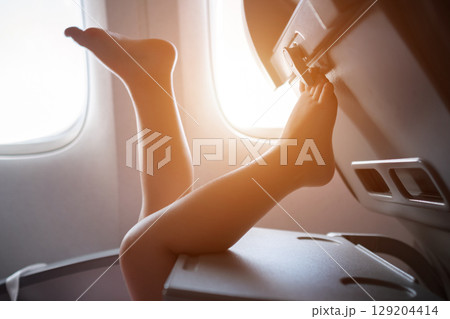 Child relaxing with feet up during airplane flight Child relaxing with feet up during airplane flight 129204414
