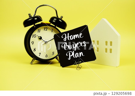 Home Buyers' Plan text with alarm clock and house model on yellow background Home Buyers' Plan text with alarm clock and house model on yellow background 129205698